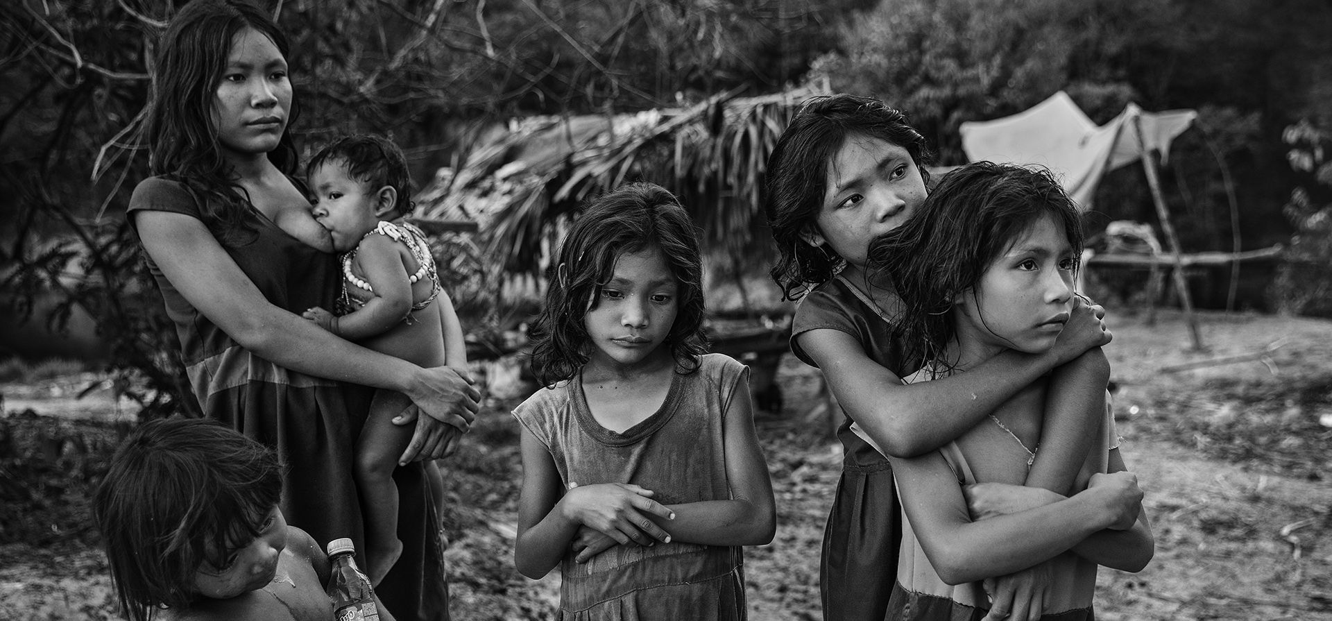Imagen de una serie titulada Amazonian Dystopia, de Lalo de Almeida para Folha de Sao Paulo/Panos Pictures que ganó el premio World Press Photo Long-Term Project, muestra a mujeres y niños de la comunidad Piraha, de pie. junto a su campamento a orillas del río Maici, observe a los conductores que pasan por la carretera transamazónica con la esperanza de que les den bocadillos o refrescos, Humaita, Amazonas, Brasil, 21 de septiembre de 2016. (Lalo de Almeida para Folha de Sao Paulo/Panos Pictures/World Press Photo vía AP)