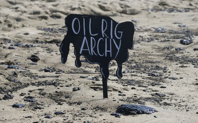 Un letrero colocado en la arena dice