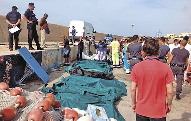 Luto. Las bolsas con los cadáveres de los emigrantes fallecidos. El barco que los transportaba se incendió y se hundió.