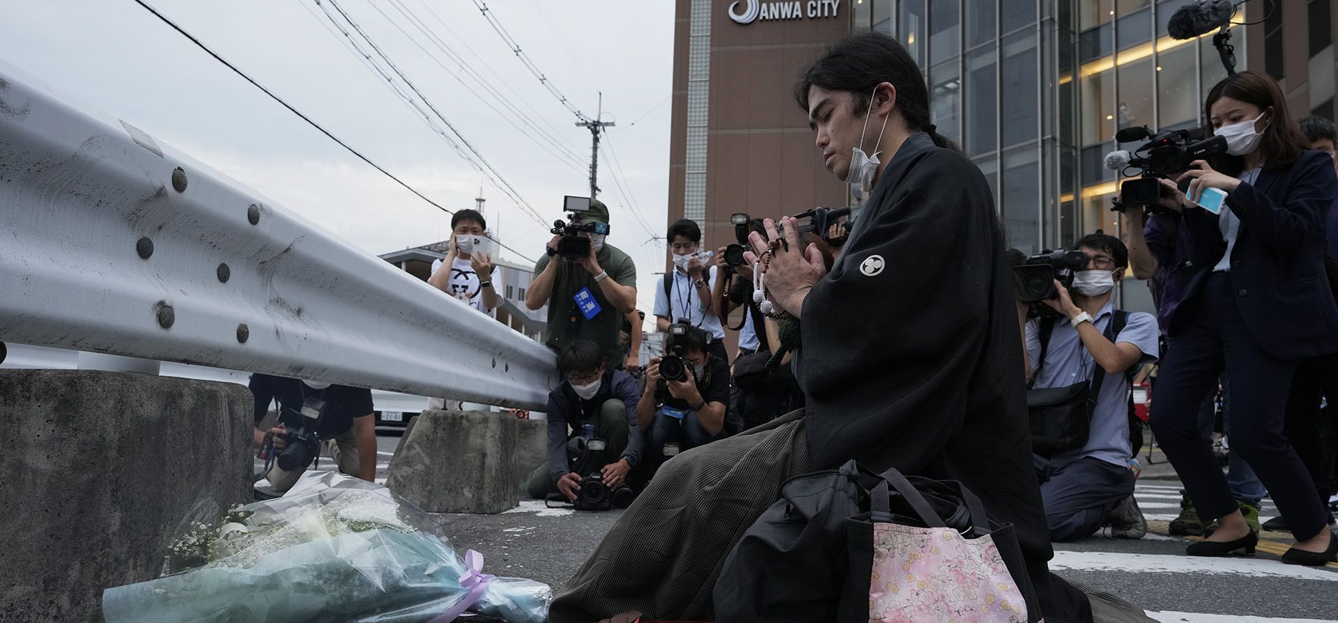 Un hombre reza frente a un monumento improvisado en la escena donde le dispararon al ex primer ministro Shinzo Abe mientras pronunciaba su discurso para apoyar al candidato del Partido Liberal Democrático durante una campaña electoral en Nara, oeste de Japón, el viernes 8 de julio de 2022.