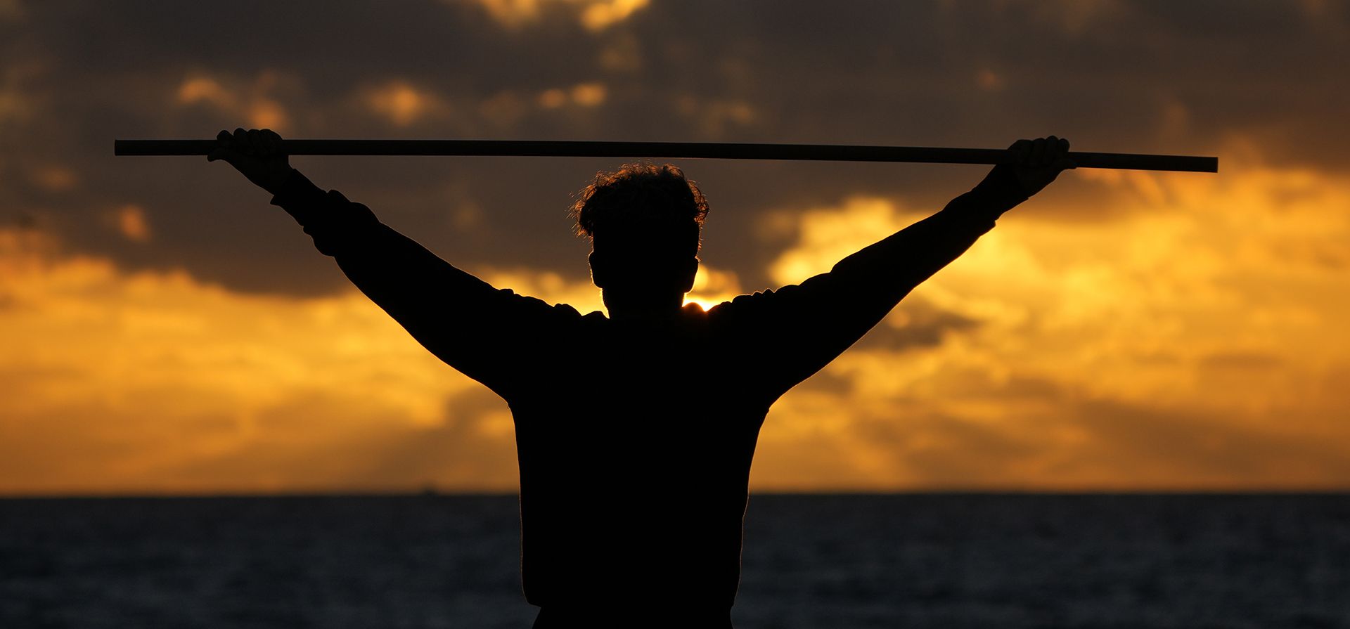 Un bañista hace ejercicio mientras el sol sale sobre el Océano Atlántico, el miércoles 1 de febrero de 2023, en Surfside, Florida (AP Photo/Wilfredo Lee)
