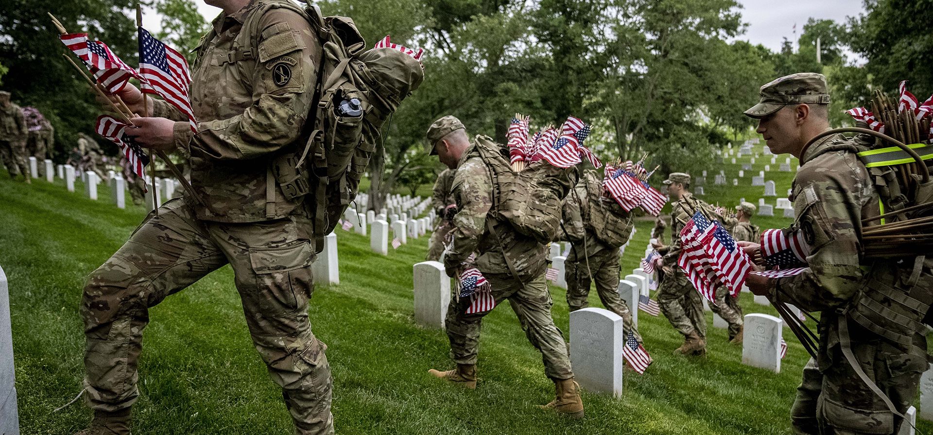 Los miembros del 3ª Regimiento de Infantería de EE. UU., también conocido como The Old Guard, colocan banderas frente a cada lápida para Los miembros del 3ª Regimiento de Infantería de EE. UU., también conocido como The Old Guard, colocan banderas frente a cada lápida para