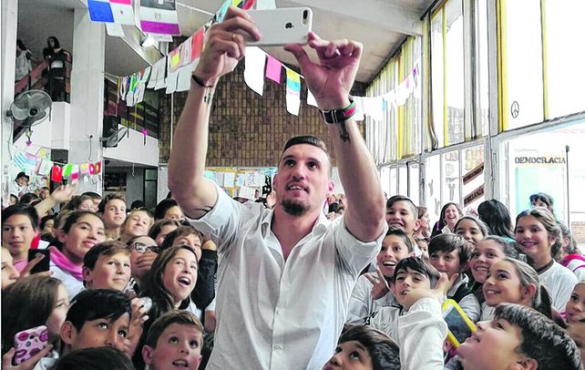 Recuerdo. El arquero de River Plate disfrutó como nunca en la escuela donde hizo la primaria y se sacó una foto con los chicos.