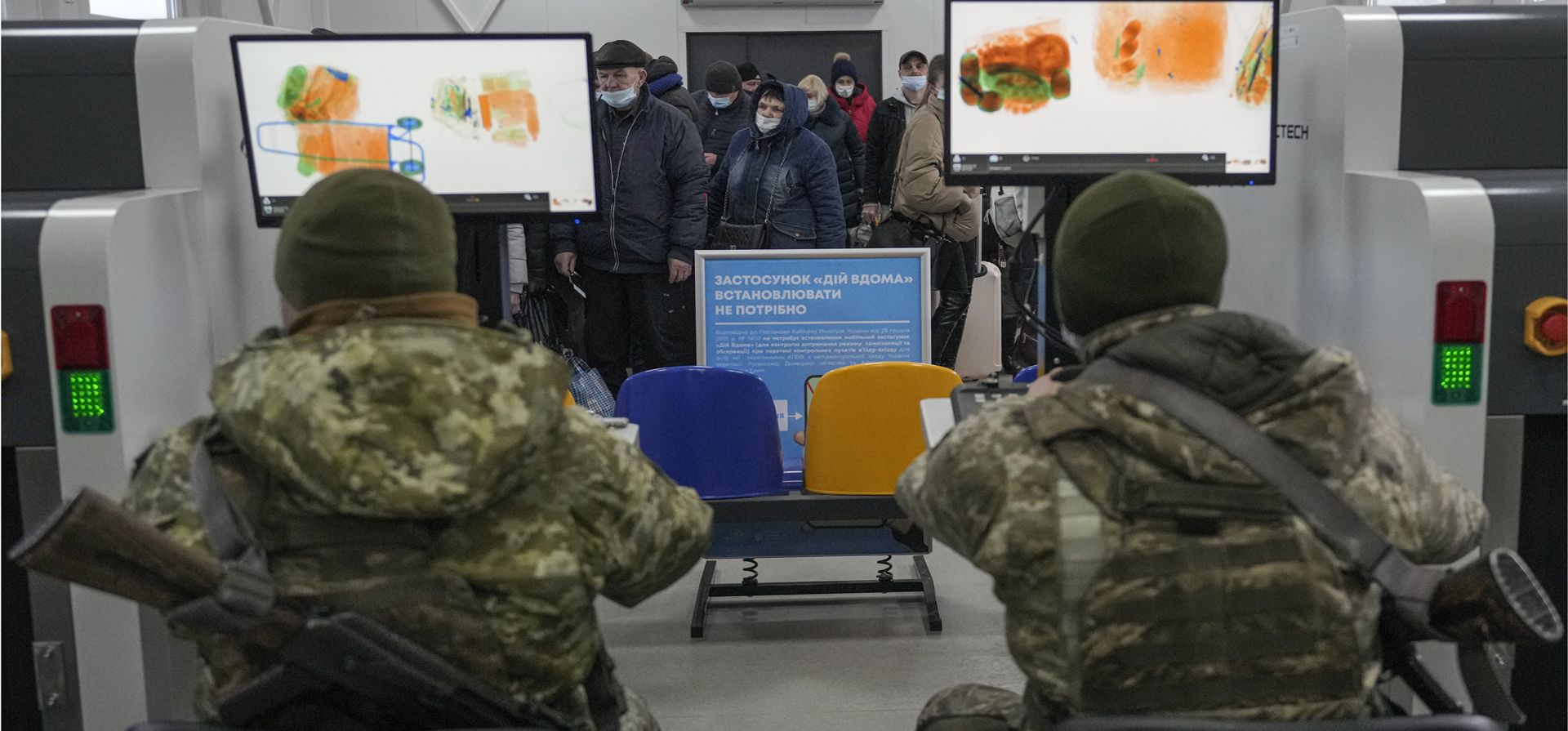 Militares ucranianos escanean las pertenencias de las personas que cruzan desde las áreas controladas por el gobierno al territorio controlado por los separatistas prorrusos en Stanytsia Luhanska, el único punto de cruce abierto todos los días, en la región de Lugansk, en el este de Ucrania.