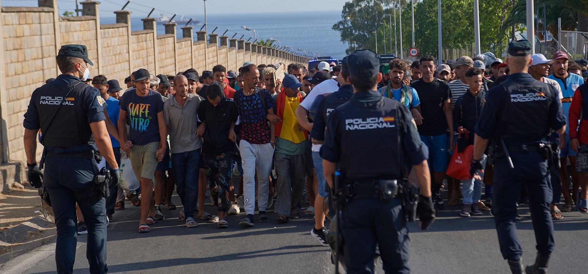 Migrantes que cruzaron de Marruecos a España son escoltados por la policía española a refugios temporales tras ser desalojados de una playa en la explanada española de Ceuta el jueves 20 de agosto de 2026. (Foto AP/Antonio Sempere) Migrantes que cruzaron de Marruecos a España son escoltados por la policía española a refugios temporales tras ser desalojados de una playa en la explanada española de Ceuta el jueves 20 de agosto de 2026. (Foto AP/Antonio Sempere)