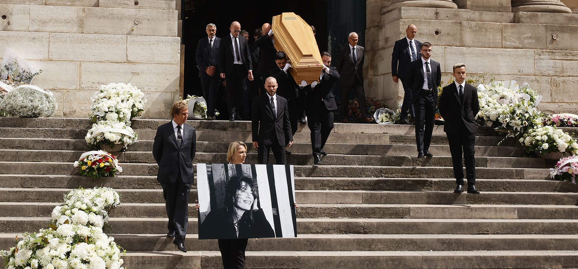 Una persona sostiene un retrato de Jane Birkin mientras los portadores del féretro cargan el ataúd de la actriz después de su ceremonia fúnebre en la iglesia de Saint-Roch en París, el lunes 24 de julio de 2023. Birkin murió la semana pasada a los 76 años. (Foto AP/Thomas Padilla) Una persona sostiene un retrato de Jane Birkin mientras los portadores del féretro cargan el ataúd de la actriz después de su ceremonia fúnebre en la iglesia de Saint-Roch en París, el lunes 24 de julio de 2023. Birkin murió la semana pasada a los 76 años. (Foto AP/Thomas Padilla)