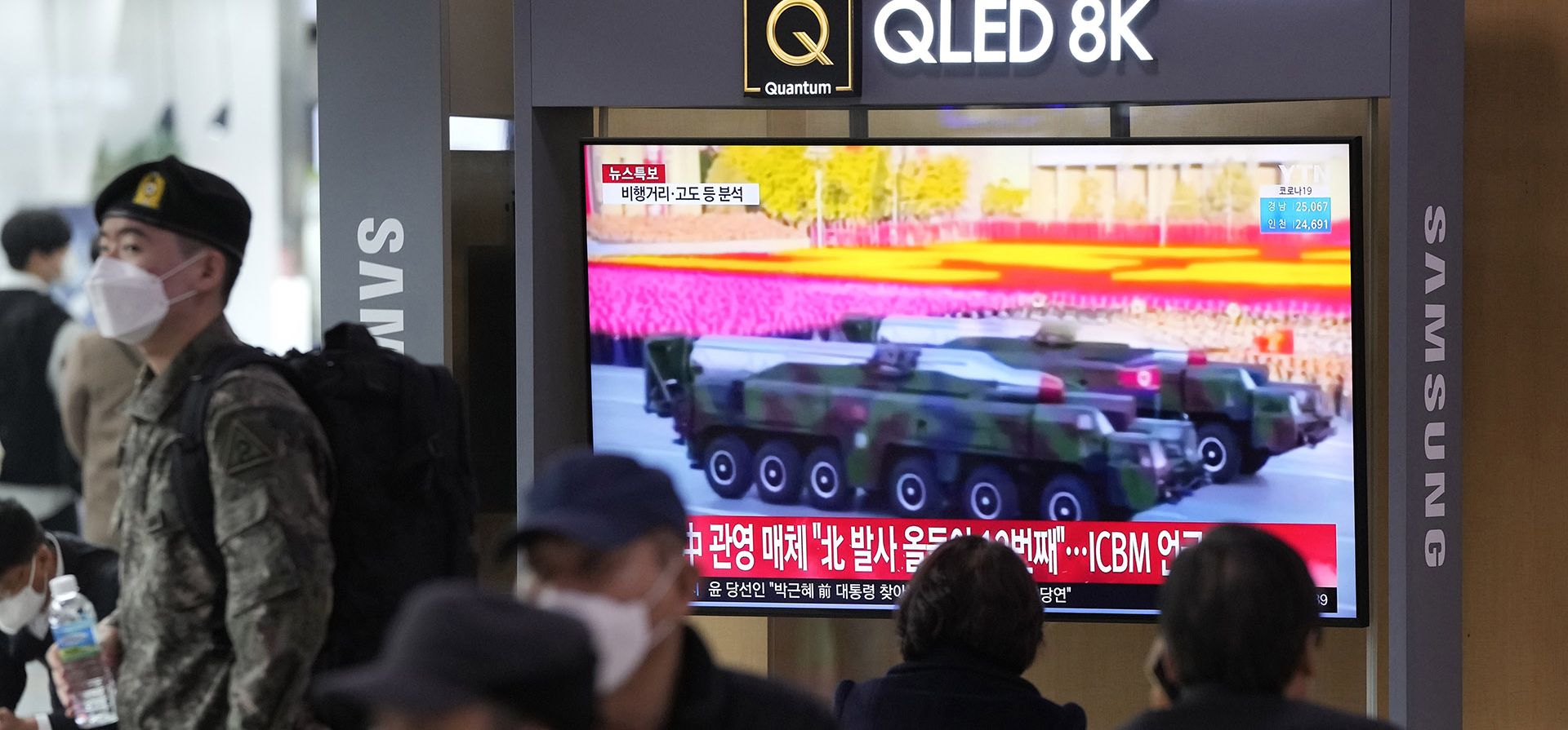 La gente mira un televisor que muestra una imagen de archivo de misiles norcoreanos en un desfile militar durante un programa de noticias en la estación de tren de Seúl, en Seúl, Corea del Sur, el jueves 24 de marzo de 2022. Corea del Norte disparó al menos un presunto misil balístico hacia el mar.