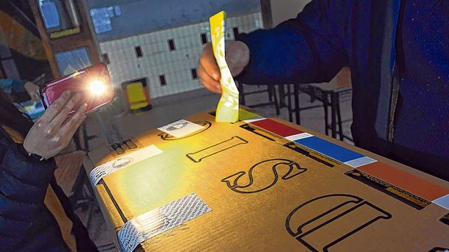 En tinieblas. Los rosarinos que madrugaron debieron iluminarse con el celular para poder emitir su voto.