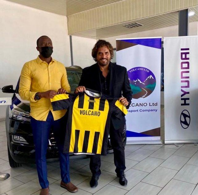 Rodolfo Zapata exhibe la camiseta de Mukura Victory junto al presidente del club aurinegro.