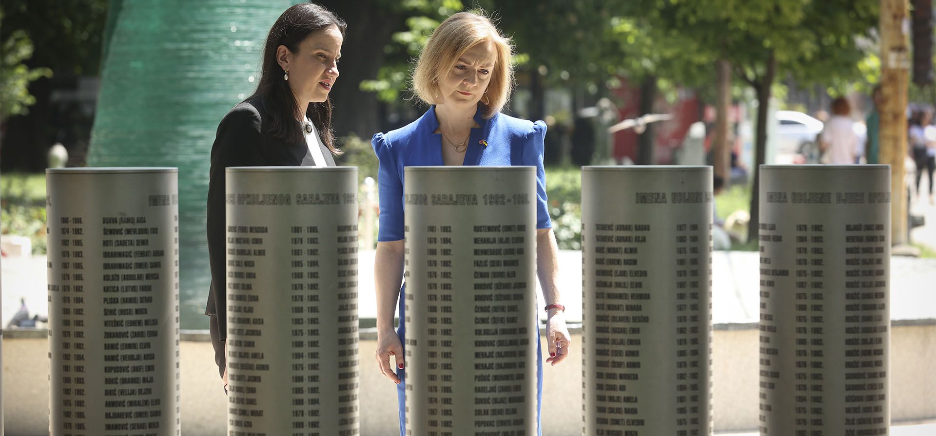 Elizabeth Truss, a la derecha, Secretaria de Estado de Asuntos Exteriores, de la Commonwealth y de Desarrollo de Gran Bretaña, mira los pilares con los nombres de las víctimas junto con la alcaldesa de Sarajevo, Benjamina Karic, en un monumento dedicado a los niños asesinados durante la guerra de Bosnia en la capital bosnia sitiada en Sarajevo, Bosnia, jueves 26 de mayo de 2022.