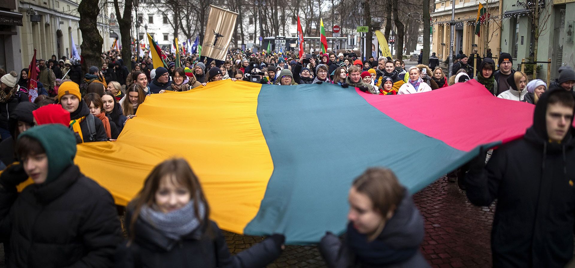 La gente lleva una bandera lituana gigante durante una celebración del Día de la Restauración del Estado en Vilnius, Lituania, el jueves 16 de febrero de 2023. Lituania celebra el aniversario de la restauración de la independencia de 1918 el 16 de febrero. (Foto AP/Mindaugas Kulbis)