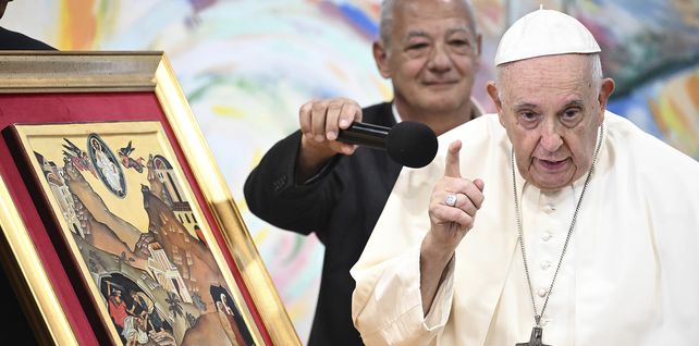 El Papa Francisco es ayudado con un micrófono por el presidente de Scholas Occurrentes, José María del Corral, mientras hace comentarios sobre una pintura que representa la parábola del "buen samaritano" durante una reunión con miembros de la comunidad de jóvenes Scholas Occurrentes, un Movimiento educativo internacional creado por el mismo Papa Francisco, en Cascais, 25 kilómetros al sur de Lisboa, el jueves 3 de agosto de 2023. (Piscina de Marco Bertorello vía AP)
