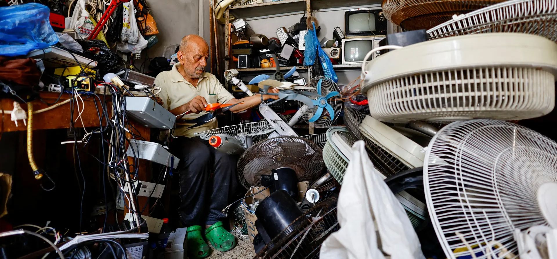 Ciudad de Gaza. Mustafa Abdou, repara un ventilador en su tienda en medio de una ola de calor en el campamento de refugiados de Shati. Fotografía: Mohammed Salem/Reuters Ciudad de Gaza. Mustafa Abdou, repara un ventilador en su tienda en medio de una ola de calor en el campamento de refugiados de Shati. Fotografía: Mohammed Salem/Reuters