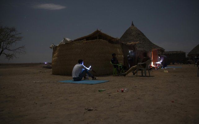 Refugiados de Tigray que huyeron del conflicto de Etiopía intentan encontrar una señal de red para sus teléfonos móviles en Hamdayet, en el este de Sudán, cerca de la frontera con Etiopía.