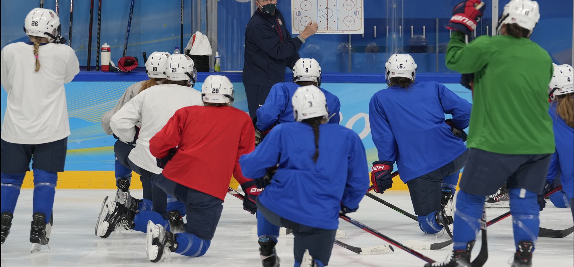 El entrenador en jefe del equipo de hockey femenino de Estados Unidos, Joel Johnson, habla con sus dirigidos durante una práctica en los Juegos Olímpicos de Invierno de 2022, el miércoles 2 de febrero de 2022 en Beijing.