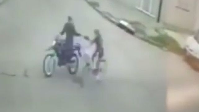 Instante en que el motochorro intenta arrebatarle la cartera a una mujer que iba en bicicleta en Marcos Paz al 5400.