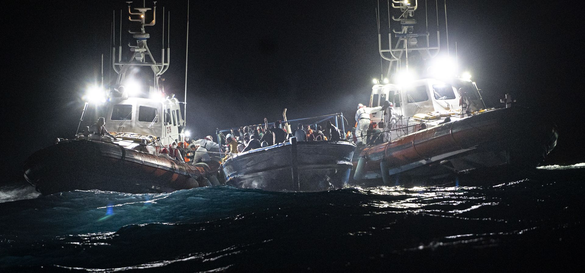 Migrantes esperan ser rescatados frente a la costa de Lampedusa, Italia, el lunes 24 de enero de 2022. Siete migrantes murieron y unos 280 han sido rescatados por la Guardia Costera italiana después de que fueran descubiertos en un bote de madera lleno frente a la costa de Italia.