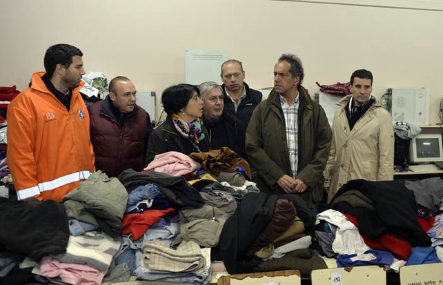 Scioli dialoga con voluntarios que trabajan para ayudar a los vecinos de Salto.