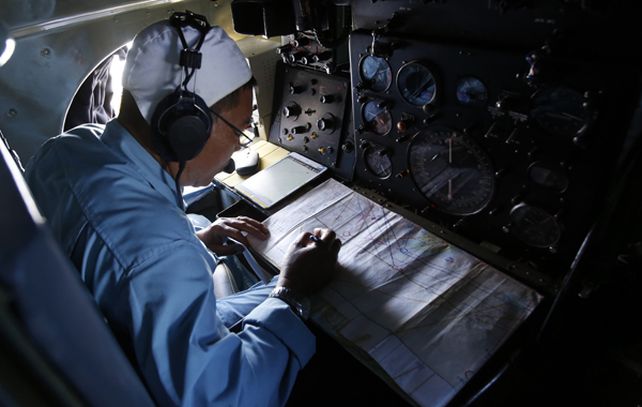Un militar trabaja en los trabajos de búsqueda del avión malayo.