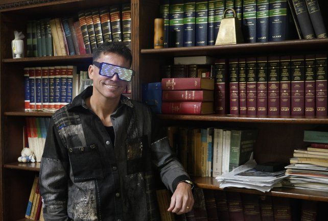 Dos en uno: Alejandro Dure en la escribanía familiar con los clásicos lentes y camisa que utiliza en sus shows.
