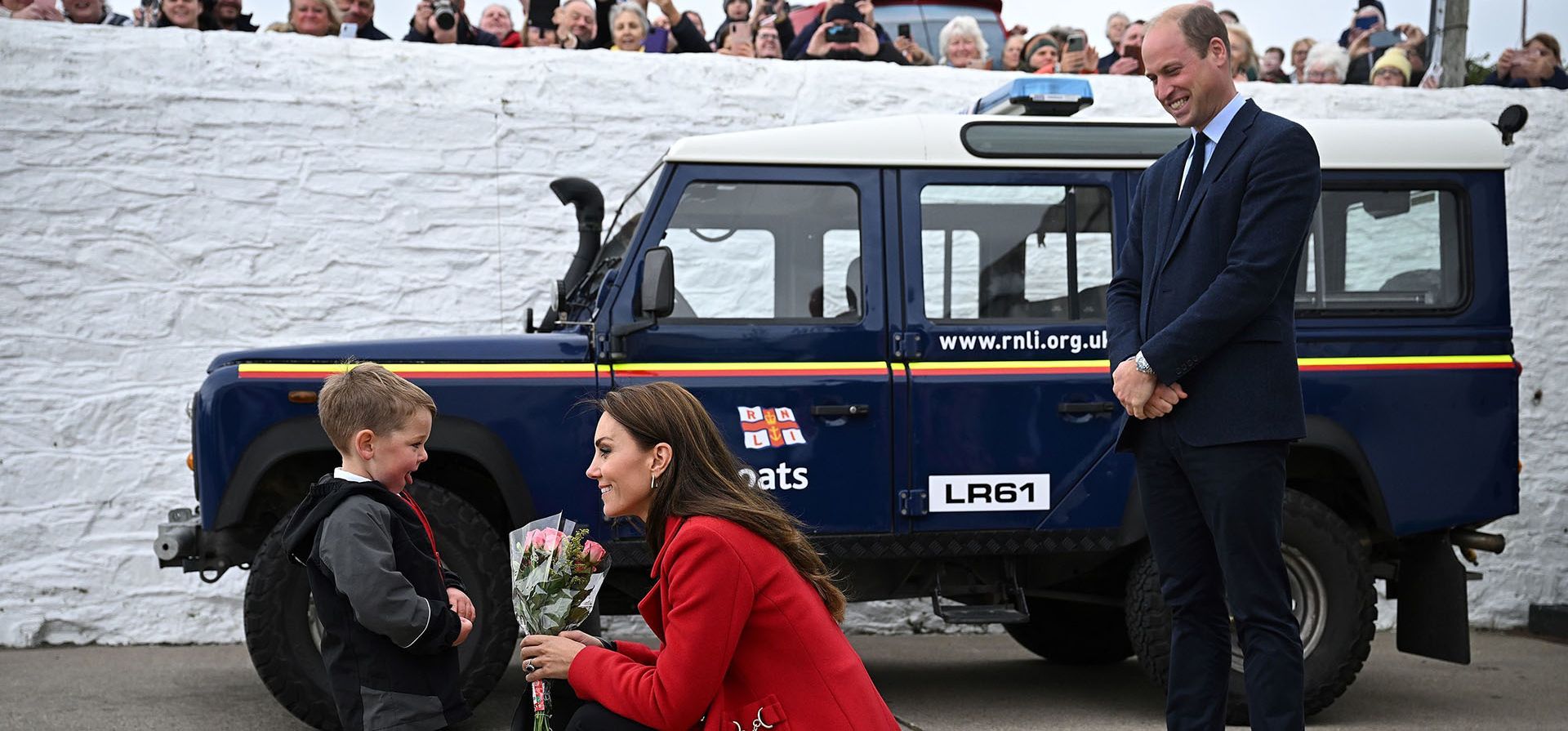 El príncipe Guillermo de Gran Bretaña, a la derecha, observa cómo Kate, princesa de Gales, recibe un ramo de flores de Theo Crompton, de cuatro años, durante una visita a la estación de botes salvavidas RNLI Holyhead, en Holyhead, Gales, donde se reúnen con la tripulación, voluntarios y algunos de los que han sido apoyados por su unidad local, el martes 27 de septiembre de 2022.