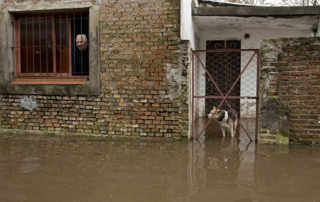 Penoso. Un vecino de un barrio de Luján soporta como puede el hecho de vivir en una casa anegada.