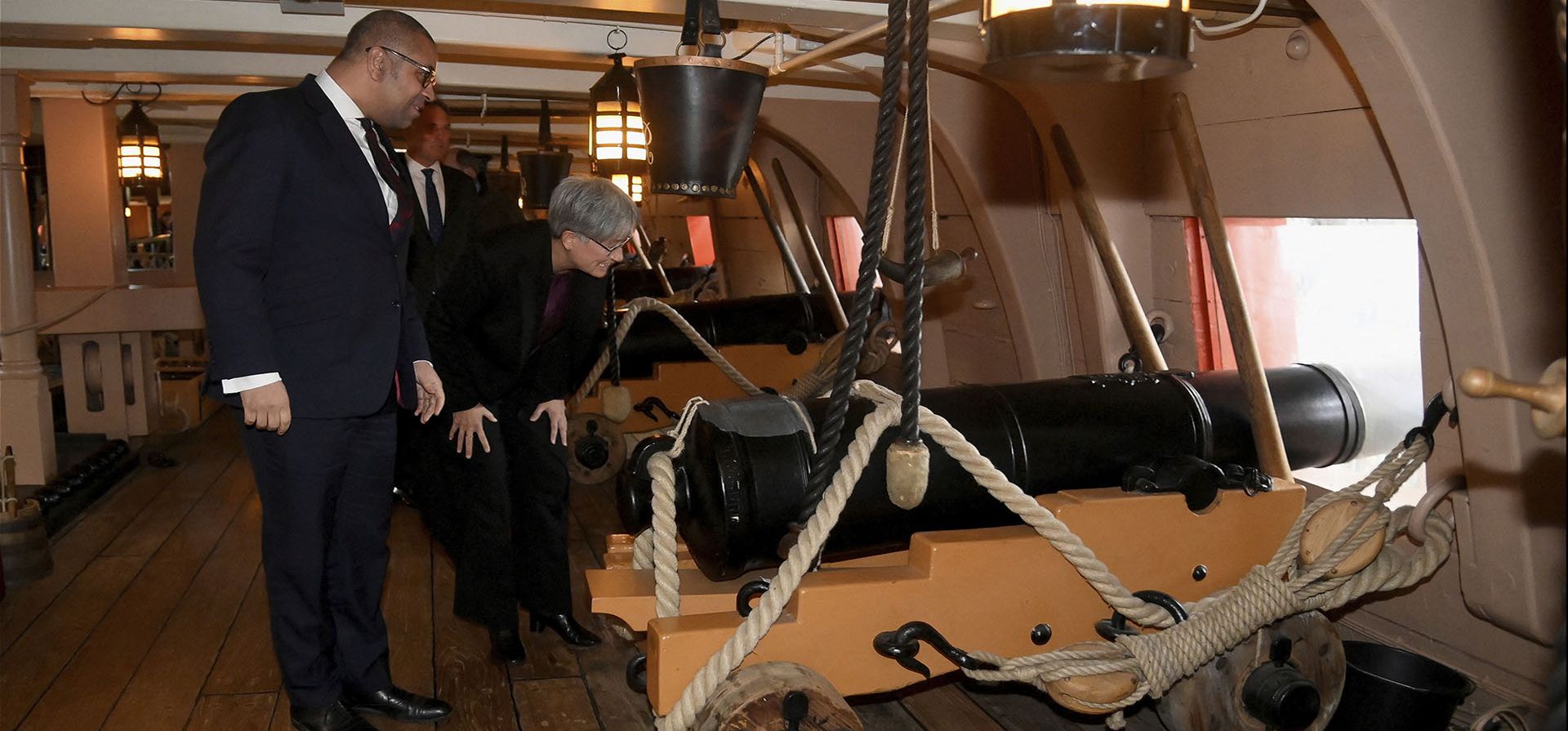 La ministra de Relaciones Exteriores de Australia, Penny Wong, y el secretario de Relaciones Exteriores británico, James Cleverly, ven un cañón en la cubierta de armas del buque de guerra británico HMS Victory en Portsmouth, Inglaterra, el jueves 2 de febrero de 2023. (Toby Melville/Pool vía AP)