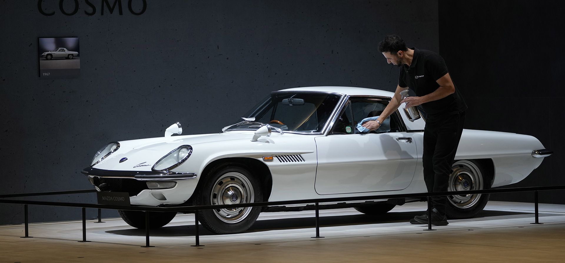 Un asistente pule un automóvil Mazda Cosmo antiguo durante la apertura para los medios de comunicación del Salón del Automóvil de Bruselas, viernes 13 de enero de 2023. (Foto AP/Virginia Mayo)