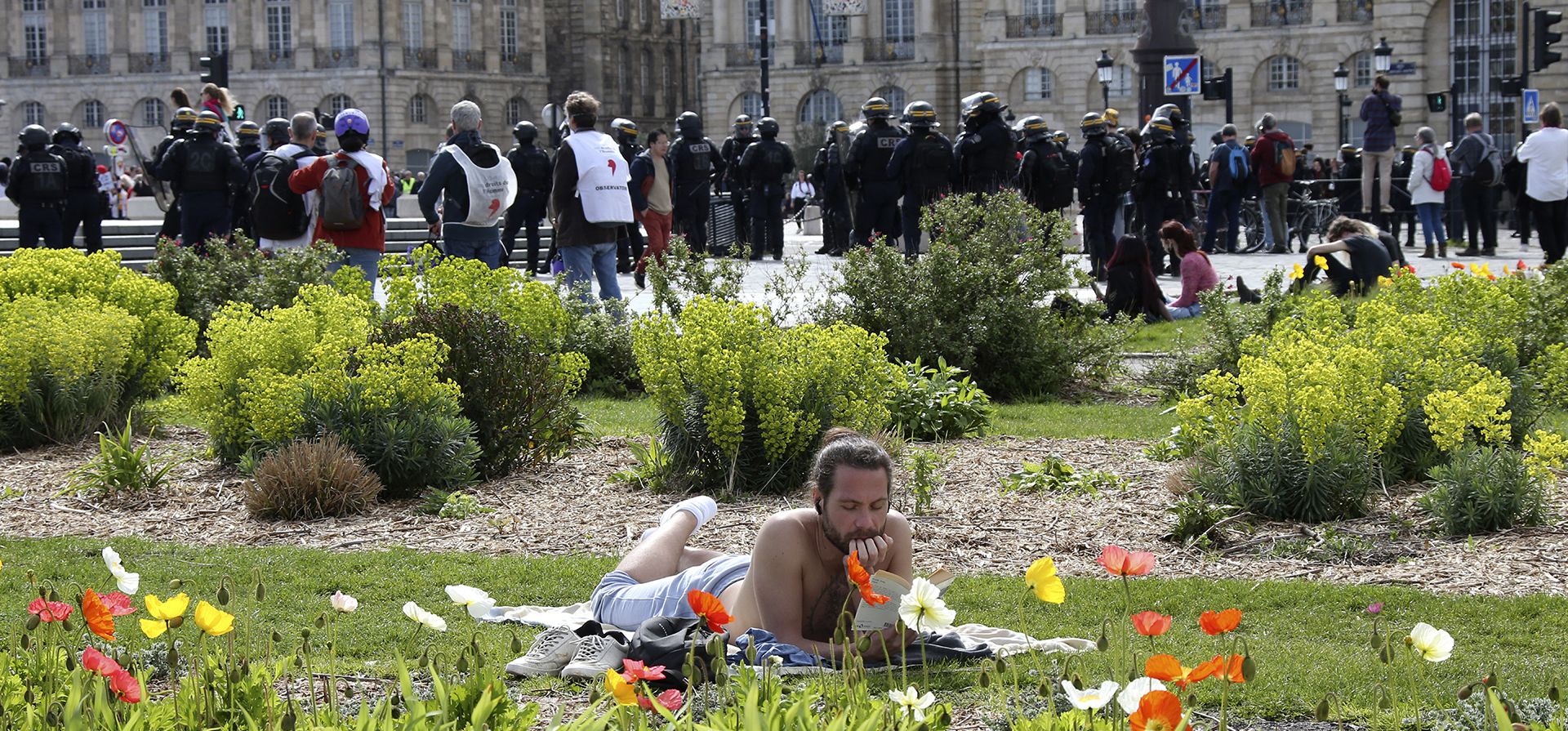 Un hombre lee en un parque durante una manifestación contra el impulso del presidente francés Emmanuel Macron para retrasar la edad legal de jubilación de Francia de 62 a 64 años. Martes, 28 de marzo de 2023 en Burdeos, suroeste de Francia. (Foto AP/Bob Edme)