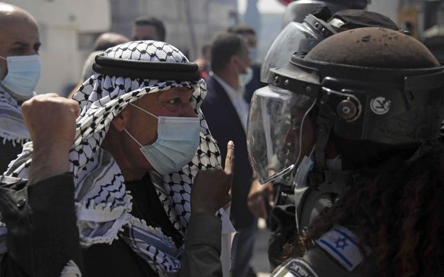 Un palestino se pelea con una policía fronteriza israelí durante una manifestación para conmemorar el Día de la Tierra y para protestar contra los colonos israelíes que visitan los sitios arqueológicos cercanos