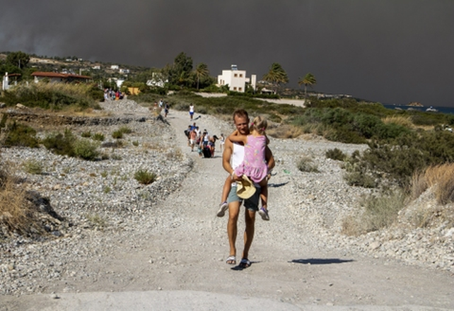 Un turista escapa con su hija en brazos del humo y las llamas en la isla de Rodas.