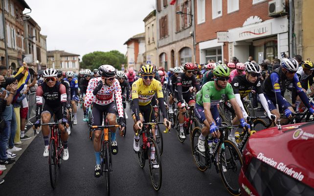 Un pelotón de ciclistas siguen al coche del director de carrera durante la neutral. Inicio de la decimoséptima etapa de la carrera ciclista del Tour de Francia.