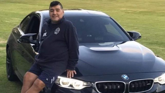 Diego Maradona con el BMW que será subastado junto con otros bienes del astro.