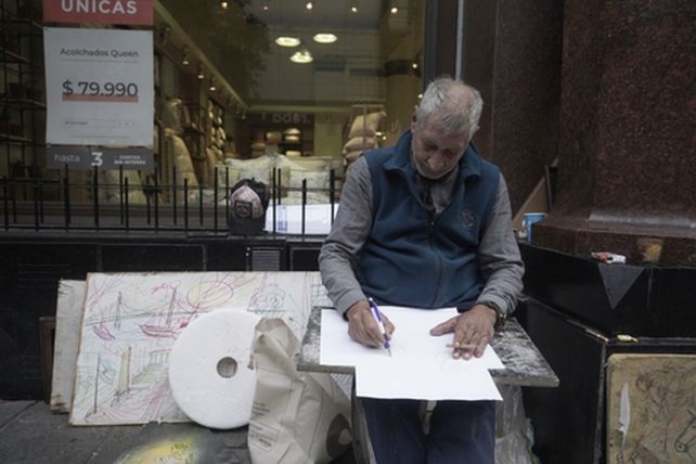 Provenzano en su puesto callejero de la peatonal casi esquina Corrientes donde dibuja y vende al paso.