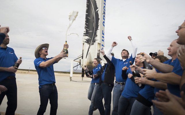 En esta foto sin fecha puesta a disposición por Blue Origin, los miembros del equipo celebran con el fundador Jeff Bezos en el lugar del aterrizaje del cohete propulsor New Shepard en el oeste de Texas.