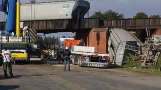Equipos de trabajadores y máquinas de Trenes Argentinos trabajan para remover los dos vagones caídos del puente La Virginia, a un costado de la ruta 33, a la altura de Pérez.