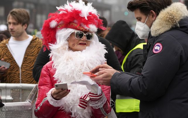 Una mujer disfrazada muestra su boleto y certificado de vacunación en las calles de Colonia, Alemania, el jueves 11 de noviembre de 2021. Después de que el carnaval fuera cancelado el año pasado debido a la pandemia de coronavirus. , este año solo las personas vacunadas con entradas pudieron asistir a las celebraciones en la plaza central de Colonia.
