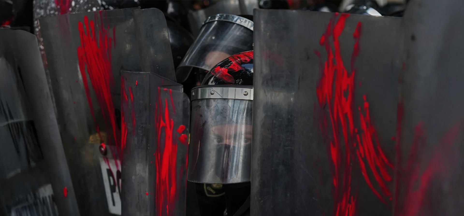 Un oficial de policía mira desde detrás de los escudos en los que los manifestantes han untado pintura en una protesta contra la guerra en Gaza, Ciudad de México. Fotografía: Fernando Llano/AP Un oficial de policía mira desde detrás de los escudos en los que los manifestantes han untado pintura en una protesta contra la guerra en Gaza, Ciudad de México. Fotografía: Fernando Llano/AP