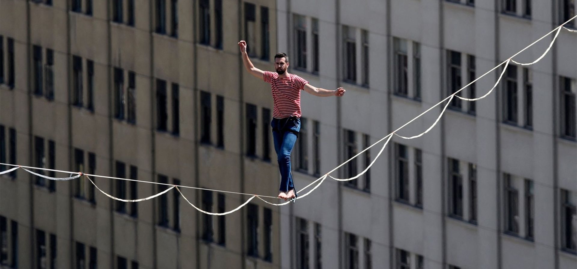 El equilibrista francés Nathan Paulin cruza la Avenida Alameda sobre una cuerda tensa de 270 metros de largo, a 50 metros del suelo, el día de la inauguración del festival Teatro a Mil, frente al Palacio Presidencial de La Moneda en Santiago. ( Foto de Javier TORRES/AFP) El equilibrista francés Nathan Paulin cruza la Avenida Alameda sobre una cuerda tensa de 270 metros de largo, a 50 metros del suelo, el día de la inauguración del festival Teatro a Mil, frente al Palacio Presidencial de La Moneda en Santiago. ( Foto de Javier TORRES/AFP)