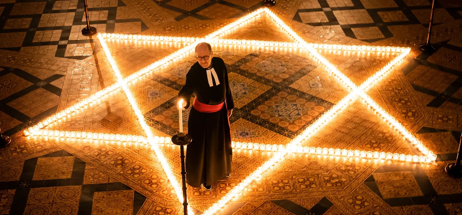 El reverendo canónigo Michael Smith, decano en funciones de York, ayuda a encender 600 velas con la forma de la estrella de David, en memoria de más de 6 millones de judíos asesinados por los nazis en la segunda guerra mundial, en la Sala Capitular de York Ministro en el Día Internacional de Recordación del Holocausto.