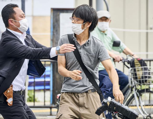 Tetsuya Yamagami, centro, sosteniendo un arma, es detenido cerca del lugar de los disparos en Nara, oeste de Japón, el viernes 8 de julio de 2022. El ex primer ministro Shinzo Abe fue asesinado el viernes en una calle del oeste de Japón por Yamagami, un hombre armado que abrió fuego sobre él por la espalda mientras pronunciaba un discurso de campaña, un ataque que sorprendió a la nación que tiene algunas de las leyes de control de armas más estrictas del mundo.