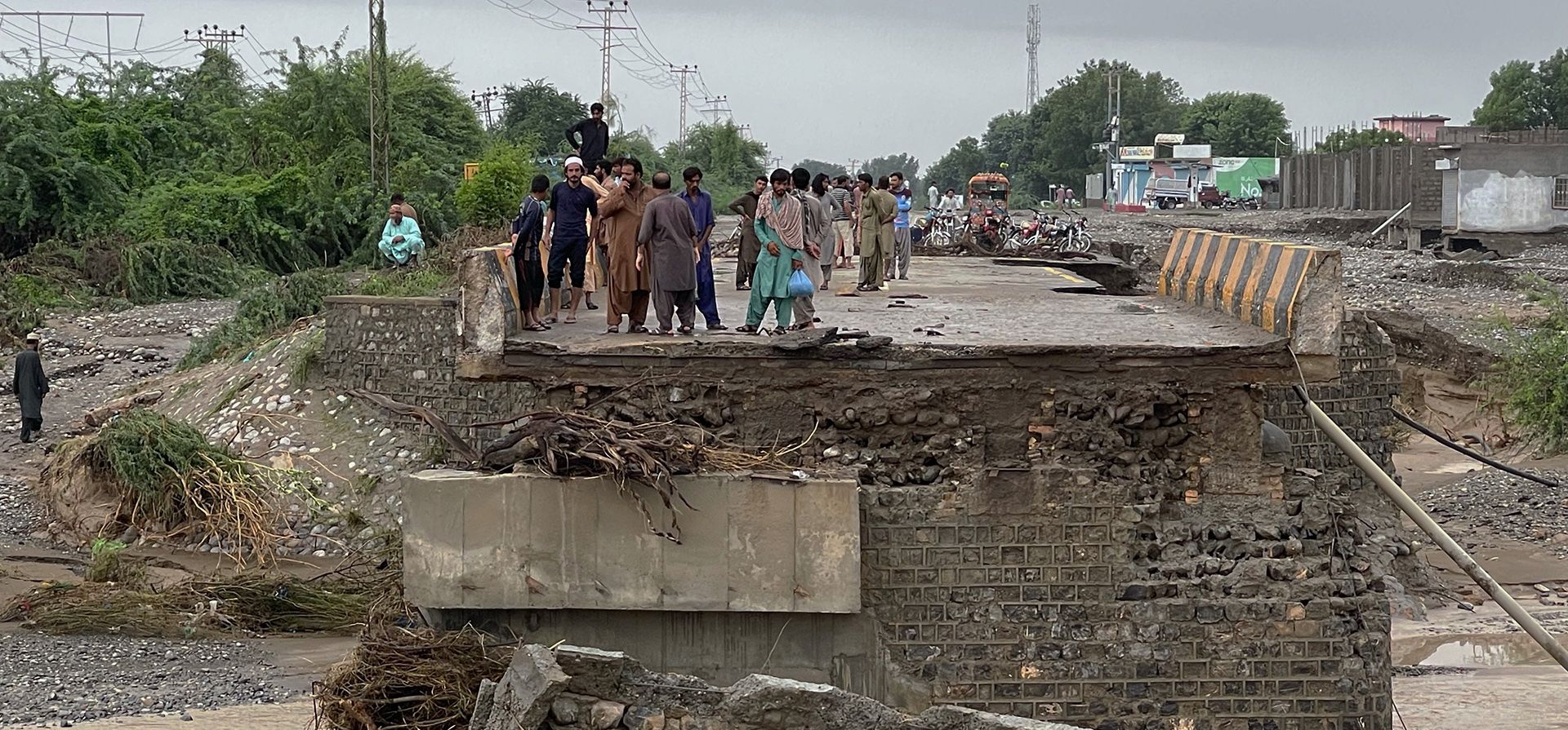 La gente examina un puente dañado después de las inundaciones debido a las fuertes lluvias, en Lasbella, un distrito en la provincia de Baluchistán, en el suroeste de Pakistán. Rescatistas respaldados por tropas utilizaron botes y helicópteros el miércoles para evacuar a cientos de personas abandonadas del suroeste del país.