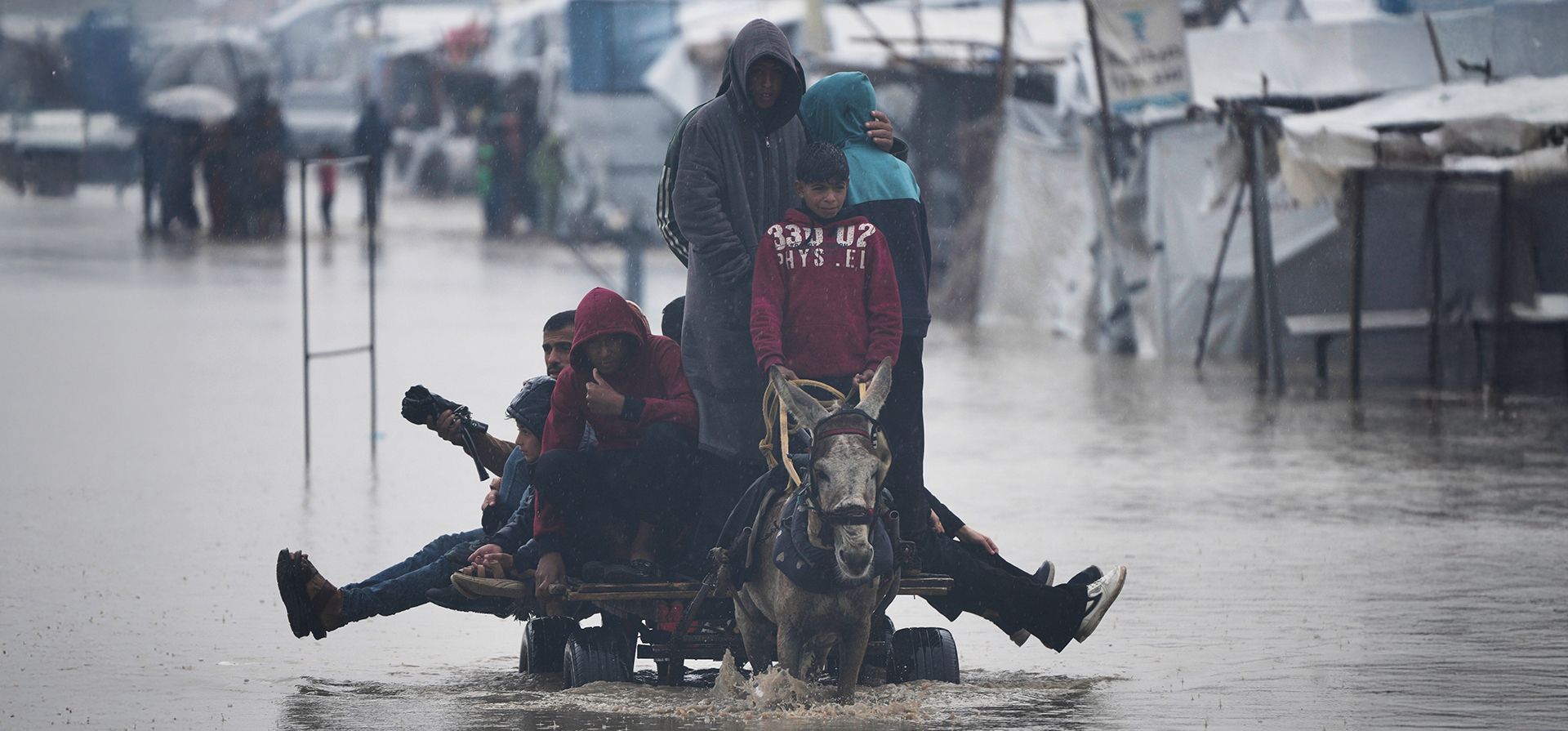 Palestinos cruzan una calle inundada tras las fuertes lluvias en Khan Younis, al sur de la Franja de Gaza, el jueves 11 de diciembre de 2025. (Foto AP/Abdel Kareem Hana) Palestinos cruzan una calle inundada tras las fuertes lluvias en Khan Younis, al sur de la Franja de Gaza, el jueves 11 de diciembre de 2025. (Foto AP/Abdel Kareem Hana)