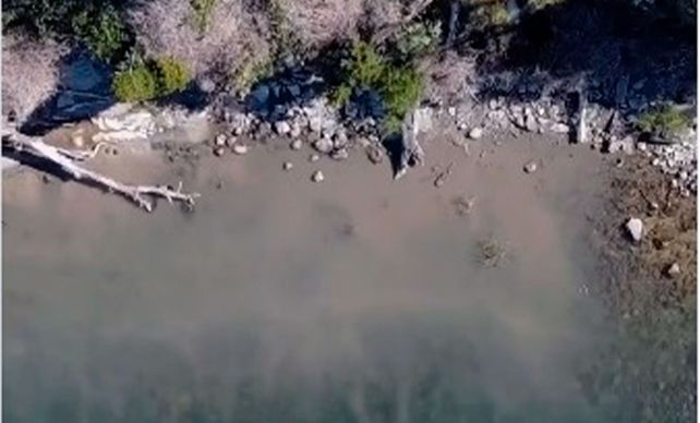 La mancha mugrienta en la orilla del lago tomada a través de un drone.