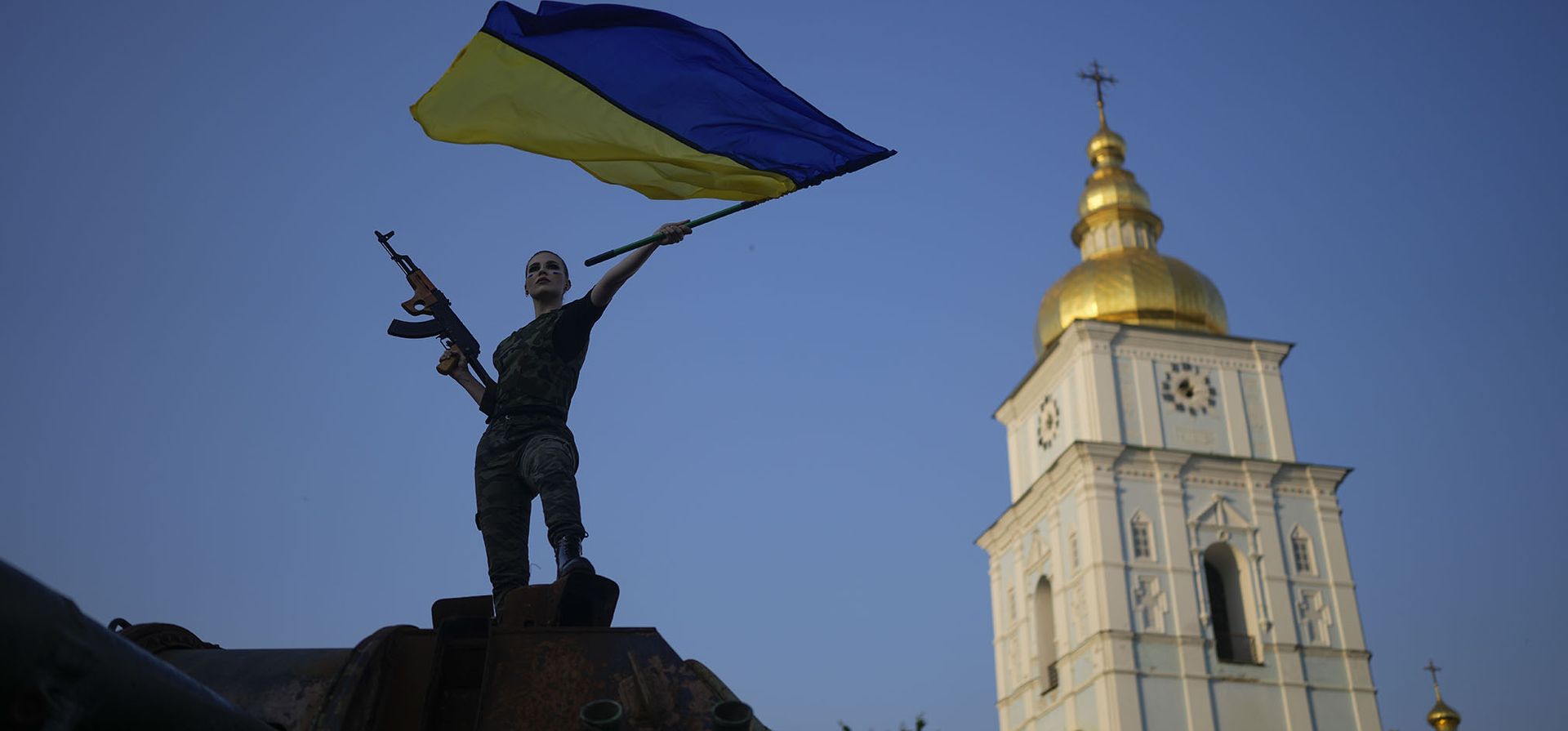 Una mujer blande la bandera ucraniana sobre un tanque ruso destruido en Kyiv, Ucrania.