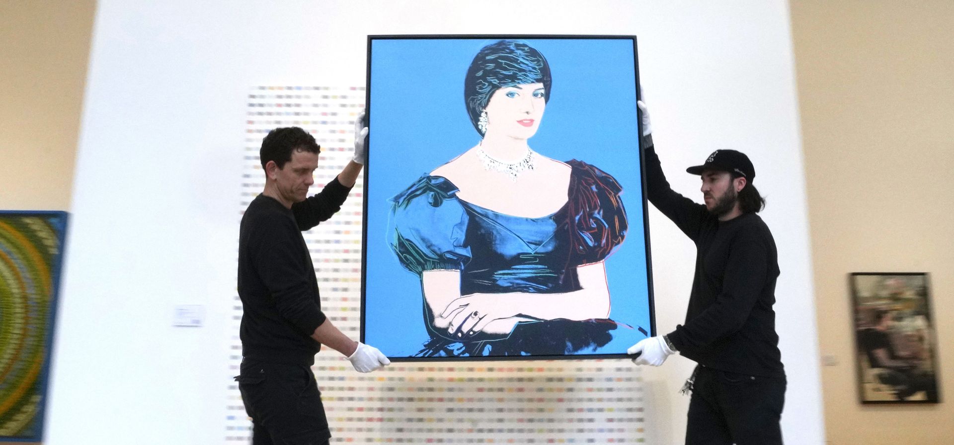 Curadores de arte llevan un retrato de Andy Warhol de la princesa Diana creado en 1982, tal como se exhibe en las salas de subastas Phillips en Londres, el jueves 29 de febrero de 2024. La pintura se estima en 1.200.00 - 1.800.00 libras esterlinas (1.520.000 - 2.280.000 dólares estadounidenses) se subastarán en las Ventas de Arte Contemporáneo y del Siglo XX de Londres los días 7 y 8 de marzo. (Foto AP/Kirsty Wigglesworth) Curadores de arte llevan un retrato de Andy Warhol de la princesa Diana creado en 1982, tal como se exhibe en las salas de subastas Phillips en Londres, el jueves 29 de febrero de 2024. La pintura se estima en 1.200.00 - 1.800.00 libras esterlinas (1.520.000 - 2.280.000 dólares estadounidenses) se subastarán en las Ventas de Arte Contemporáneo y del Siglo XX de Londres los días 7 y 8 de marzo. (Foto AP/Kirsty Wigglesworth)