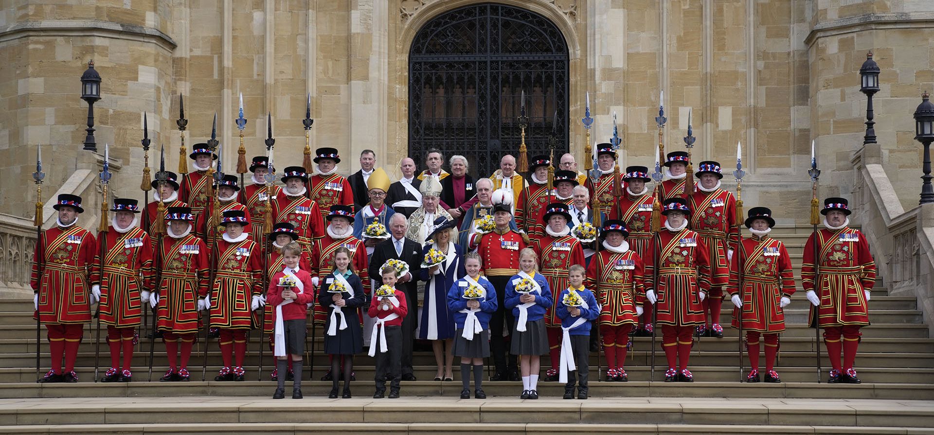 El príncipe Carlos y Camila, duquesa de Cornualles de Gran Bretaña, posan con ramilletes de flores al salir del Servicio Real Real en la Capilla de San Jorge en Windsor, Inglaterra, el jueves 14 de abril de 2022.
