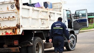 Un bombero salva del agua colchones que son trasladados en un camión de la Municipalidad de Concordia. &nbsp; 