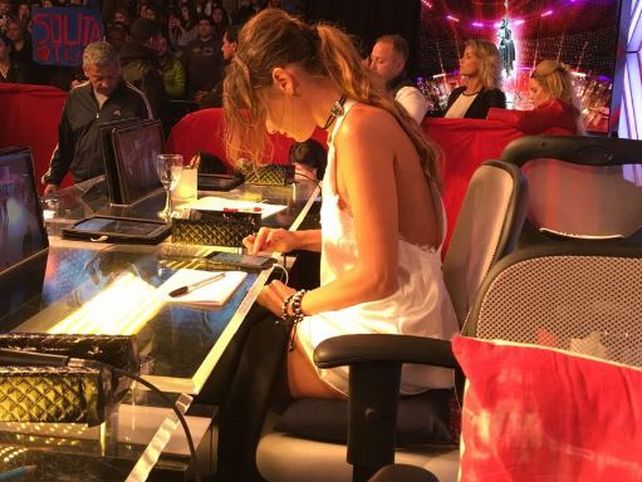 Pampita fue fotografiada mientras miraba su teléfono en pleno show.