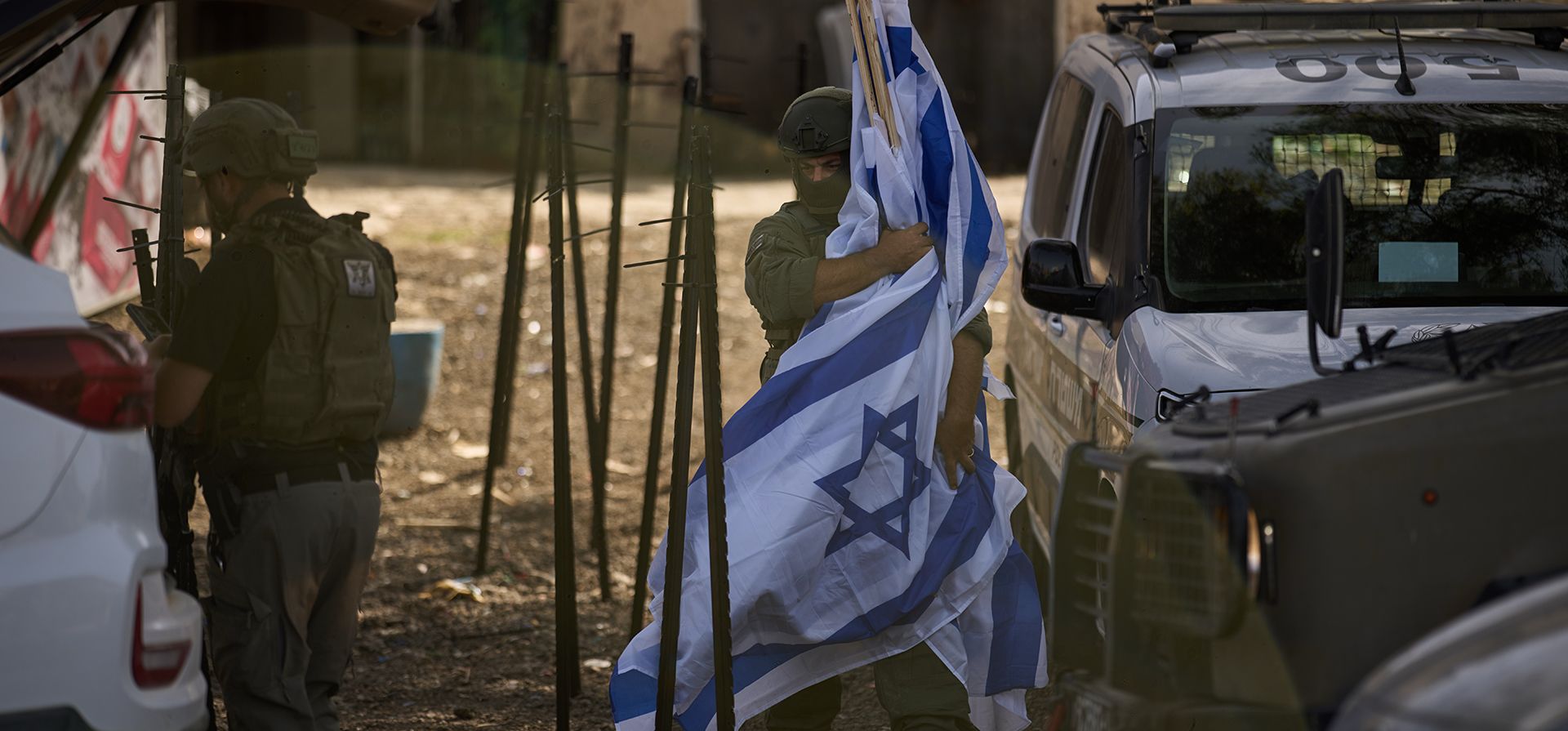 Un colono israelí transporta banderas después de que se colocaran decenas de otras banderas israelíes frente a una tienda propiedad del palestino Mouayad Oweis, bloqueando el acceso a su negocio en la localidad de al-Lubban al-Sharqiya, en Cisjordania, el jueves 8 de octubre de 2026. (Foto AP/Leo Correa) Un colono israelí transporta banderas después de que se colocaran decenas de otras banderas israelíes frente a una tienda propiedad del palestino Mouayad Oweis, bloqueando el acceso a su negocio en la localidad de al-Lubban al-Sharqiya, en Cisjordania, el jueves 8 de octubre de 2026. (Foto AP/Leo Correa)